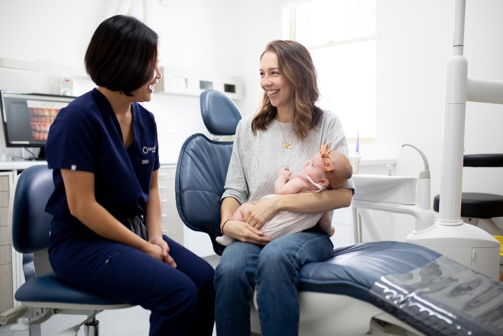 mother holding child during infant oral health exam in highgate hill